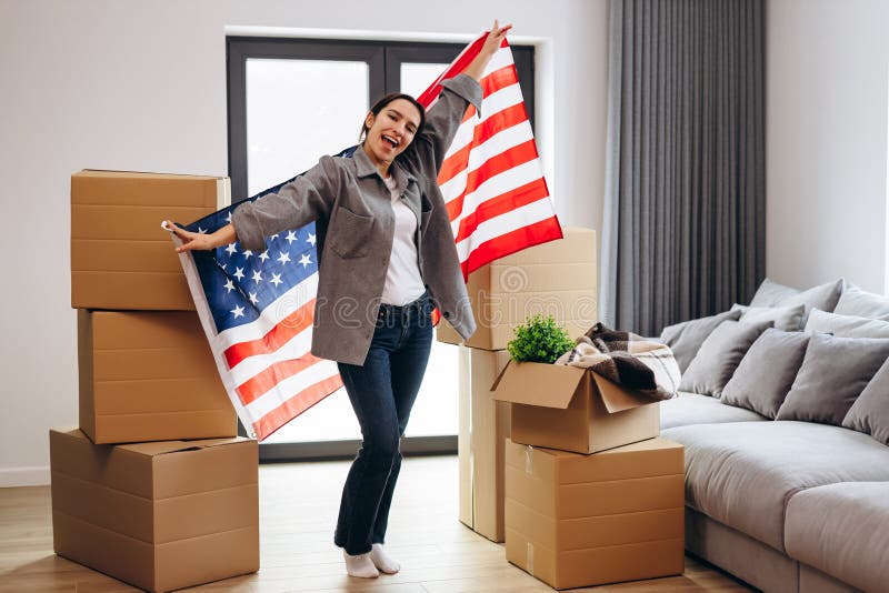 An American woman moved to a new house. Dancing with the US flag. An American woman moved to a new house. Dancing with the US flag.