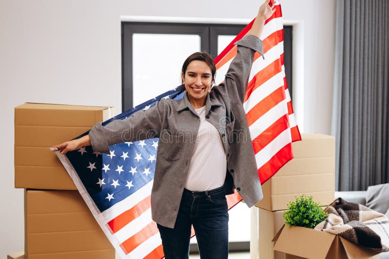 An American woman moved to a new house. Dancing with the US flag. An American woman moved to a new house. Dancing with the US flag.