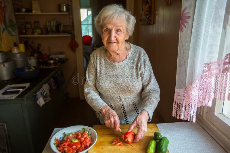 Una donna anziana prepara un pasto