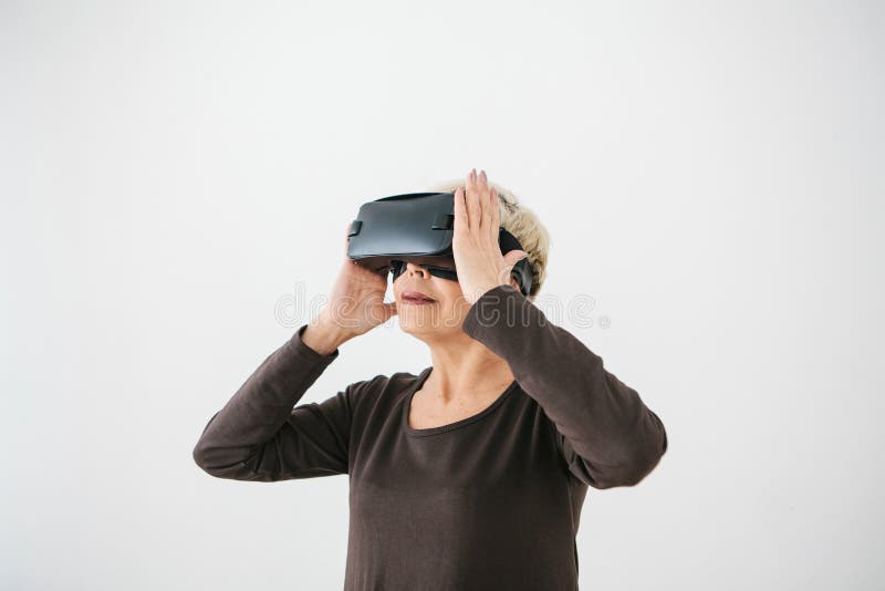 Una donna anziana in vetri di realtà virtuale Una persona anziana che usando tecnologia moderna fotografia stock Una donna anziana in vetri di realtà virtuale Una persona anziana che usando tecnologia moderna fotografia stock
