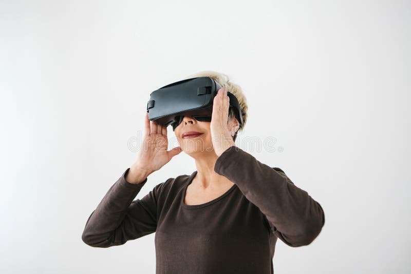 Una donna anziana in vetri di realtà virtuale Una persona anziana che usando tecnologia moderna immagini stock libere da diritti Una donna anziana in vetri di realtà virtuale Una persona anziana che usando tecnologia moderna immagini stock libere da diritti