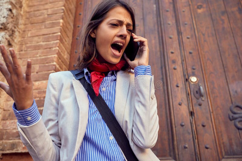 Una donna arrabbiata al telefono cellulare fotografia stock libera da diritti Una donna arrabbiata al telefono cellulare fotografia stock libera da diritti