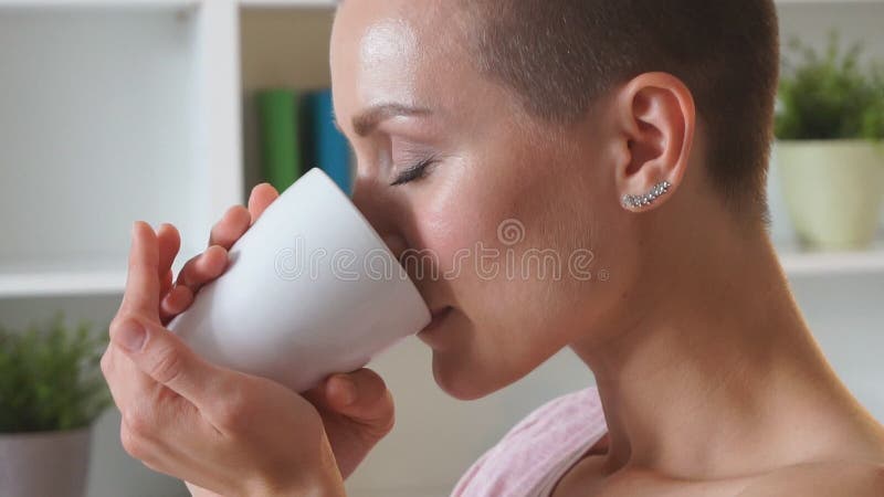 Una donna caucasica incantevole con una tazza di tè sul letto