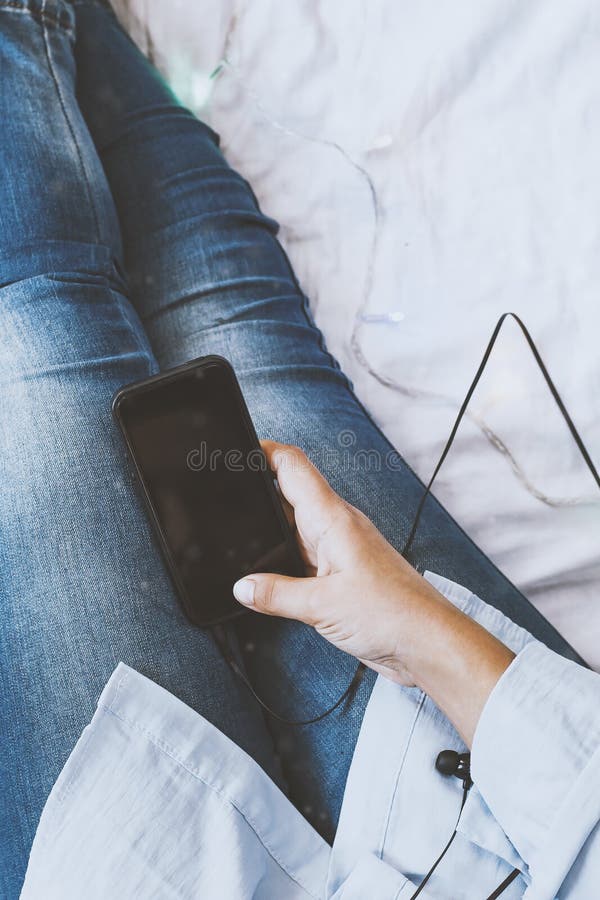 Una donna che cerca di dormire dopo una giornata di duro lavoro Le donne si rilassano in una camera accogliente Ascoltare musica fotografia stock Una donna che cerca di dormire dopo una giornata di duro lavoro Le donne si rilassano in una camera accogliente Ascoltare musica fotografia stock