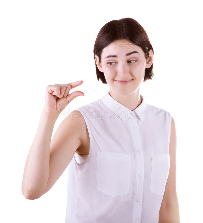 Una donna che mostra con la sua mano qualche cosa di piccolo Una ragazza scettica isolata su un fondo bianco Una signora castana fotografia stock Una donna che mostra con la sua mano qualche cosa di piccolo Una ragazza scettica isolata su un fondo bianco Una signora castana fotografia stock