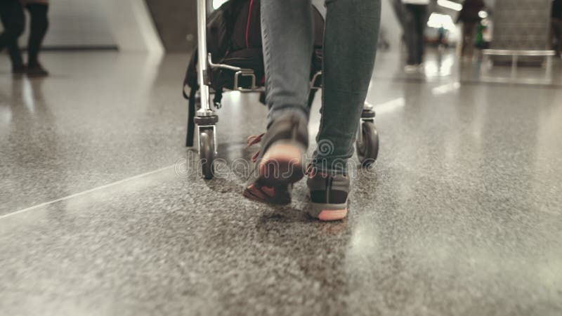 Una donna che porta carro al terminal dell'aeroporto internazionale