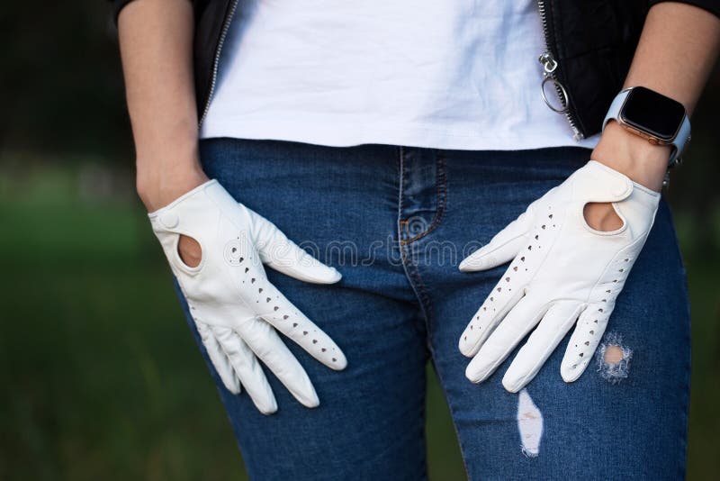 Una donna con una brutale giacca di pelle nera e guanti di pelle bianca fotografia stock