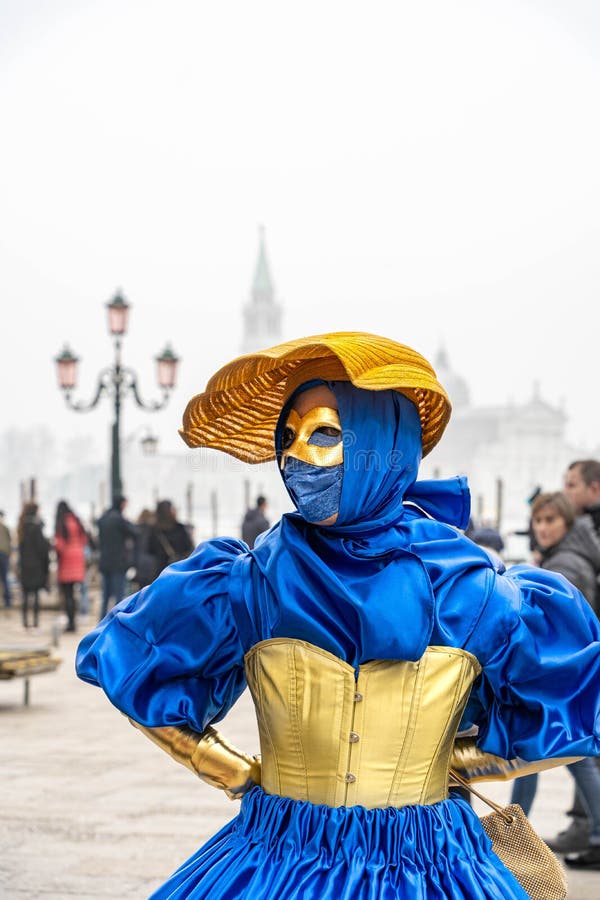 Una Donna Con Cappello Giallo E Vestito Blu è Sola Per Strada a Carnival in  Venice Italia Immagine Stock Editoriale - Immagine di italiano, mascherina:  267908729