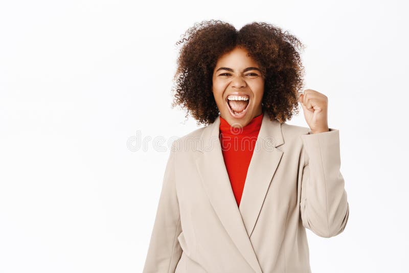 Una donna d'affari nera entusiasta celebra il pugno e grida di gioia per la vittoria fotografia stock libera da diritti