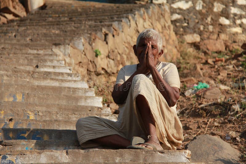 Una donna del mendicante con un gesto di ciao dall'India