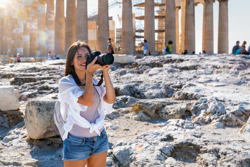 Una donna fotografa il tempio del Partenone nell'Acropoli di Atene fotografia stock Una donna fotografa il tempio del Partenone nell'Acropoli di Atene fotografia stock