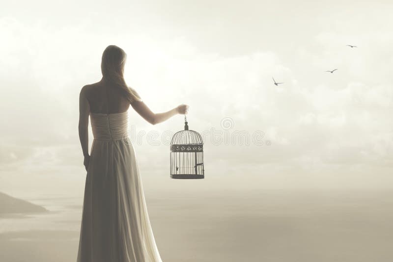 Una donna libera un uccello dalla gabbia e lo guarda volare via nel cielo con altri uccelli
