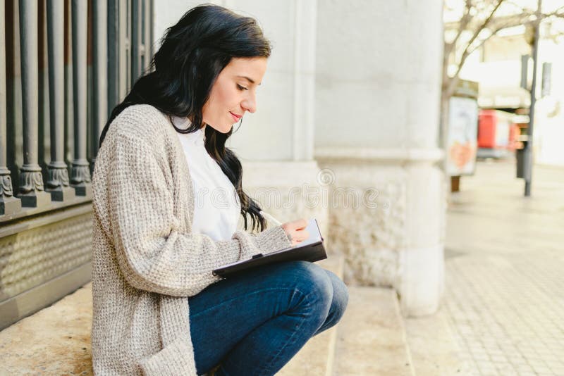 Una donna matura ritratta che prende appunti nel suo taccuino, indicando i suoi sogni e i suoi piani futuri fotografia stock libera da diritti Una donna matura ritratta che prende appunti nel suo taccuino, indicando i suoi sogni e i suoi piani futuri fotografia stock libera da diritti