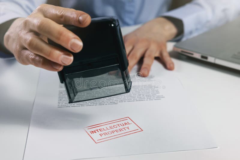 Una donna mette un francobollo sulla proprietà intellettuale su un documento