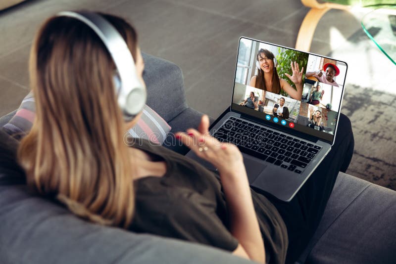 Una donna partecipa a una videoconferenza guardando lo schermo del portatile durante una riunione virtuale come webcam per l'azien fotografia stock