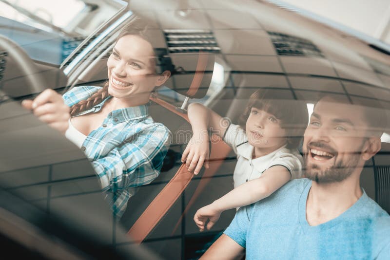 Una donna sta sedendosi alla ruota di nuova automobile fotografia stock Una donna sta sedendosi alla ruota di nuova automobile fotografia stock