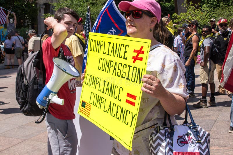 A woman holds a sign that reads `Compliance does not equal compassion. Compliance equals complacency`. Taken at a conservative rally supporting Donald Trump, and against mask mandates due to COVID-19. July 18th 2020. Downtown Columbus Ohio. Stand for America Rally. A woman holds a sign that reads `Compliance does not equal compassion. Compliance equals complacency`. Taken at a conservative rally supporting Donald Trump, and against mask mandates due to COVID-19. July 18th 2020. Downtown Columbus Ohio. Stand for America Rally.