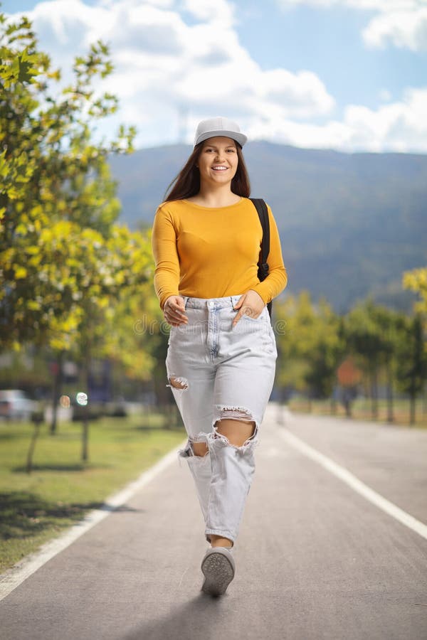 Una estudiante feliz caminando por un parque fotografía de archivo libre de regalías
