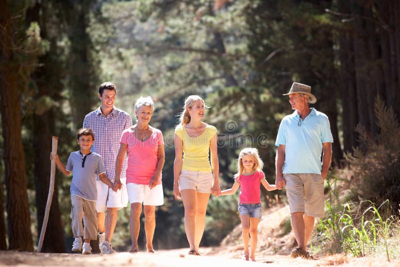 Una famiglia delle 3 generazioni che cammina lungo la strada campestre fotografia stock Una famiglia delle 3 generazioni che cammina lungo la strada campestre fotografia stock