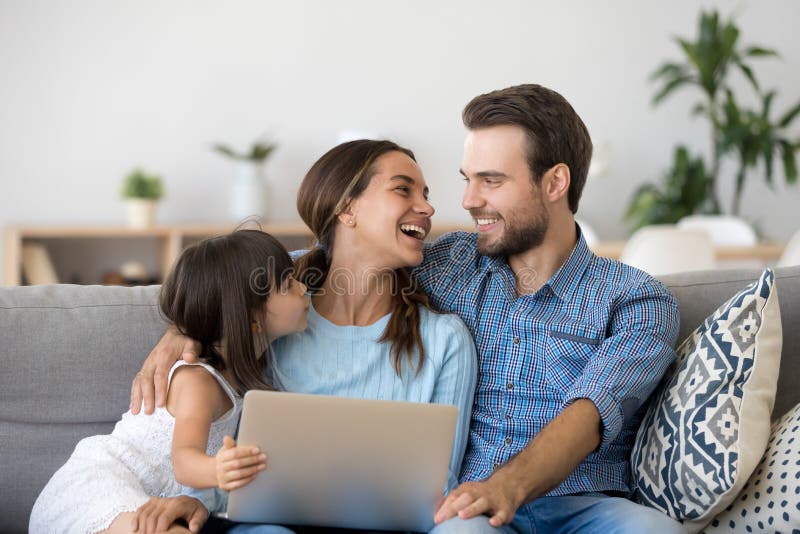 Una famiglia felice di legame tre facendo uso del computer portatile che si siede sullo strato