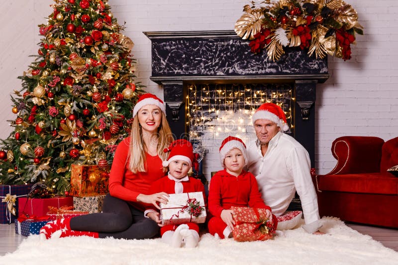 Una Familia De Cuatro Miembros En Un Vestido Rojo Para La Navidad Foto de  archivo - Imagen de bebé, luces: 132516500