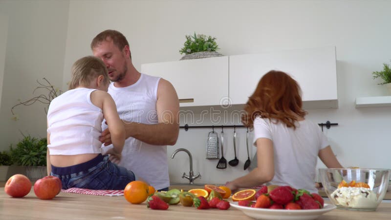 Una familia unida feliz juega sobre al cocinar un desayuno en la cocina Toda la familia hace un desayuno en cocina