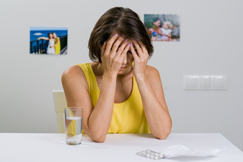 Una femmina adulta soffre da un'emicrania severa immagini stock libere da diritti Una femmina adulta soffre da un'emicrania severa immagini stock libere da diritti
