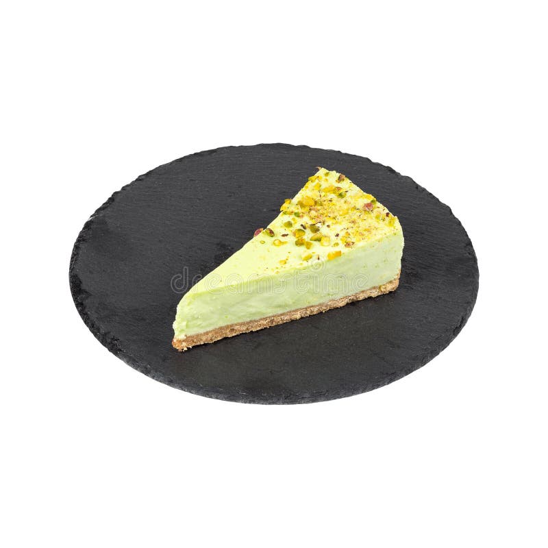 Una fetta di cheesecake al pistacchio su una piastra nera di ardesia con una trama cremosa di pasta ed elegante fotografia stock libera da diritti