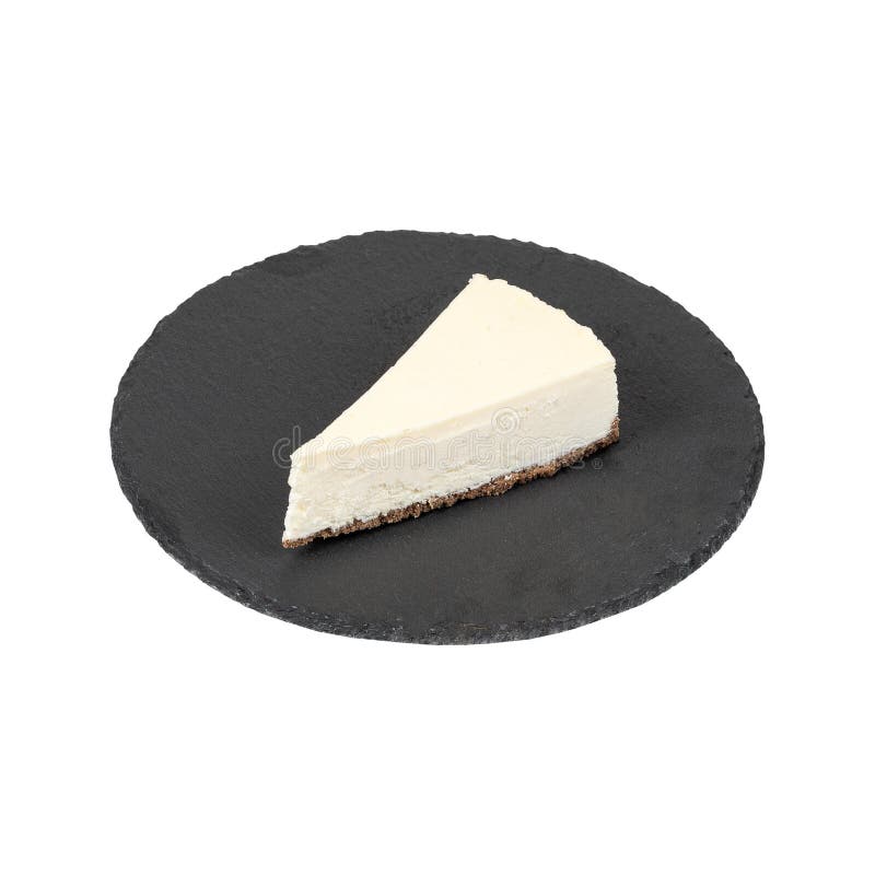 Una fetta di cheesecake cremosa con crosta di cracking di graham su una piastra di ardesia nera isolata su fondo bianco fotografie stock