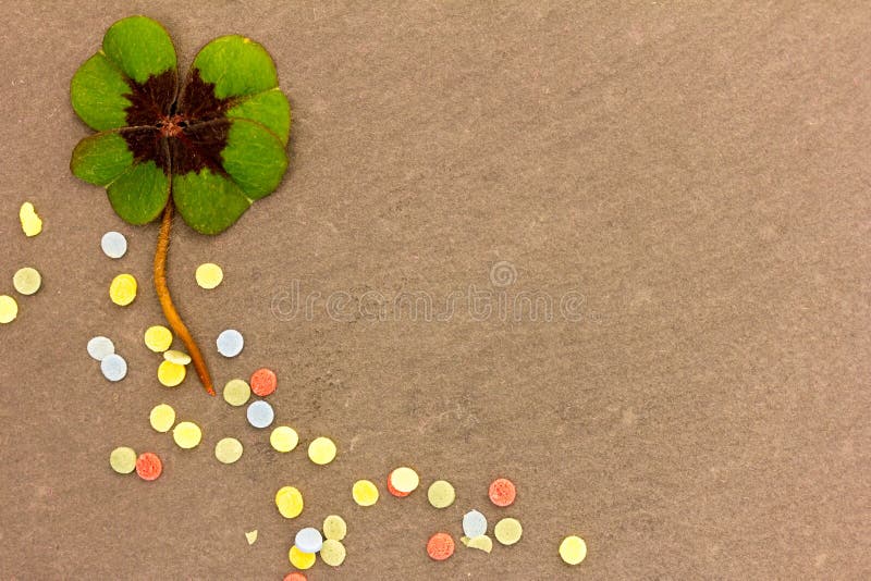 A clover leaf lies on a background of stone. A clover leaf lies on a background of stone