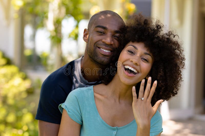 Una giovane coppia felice con una donna che mostra la fede nuziale