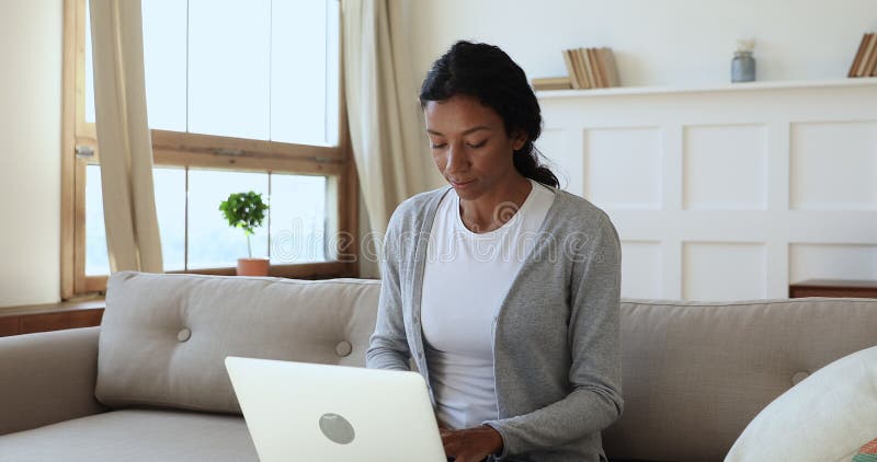 Una giovane donna di etnia africana concentrata scrive messaggi al computer