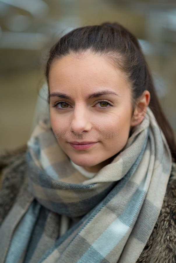 Una giovane donna femminile bianca esamina la macchina fotografica vestita per l'inverno fotografia stock libera da diritti Una giovane donna femminile bianca esamina la macchina fotografica vestita per l'inverno fotografia stock libera da diritti