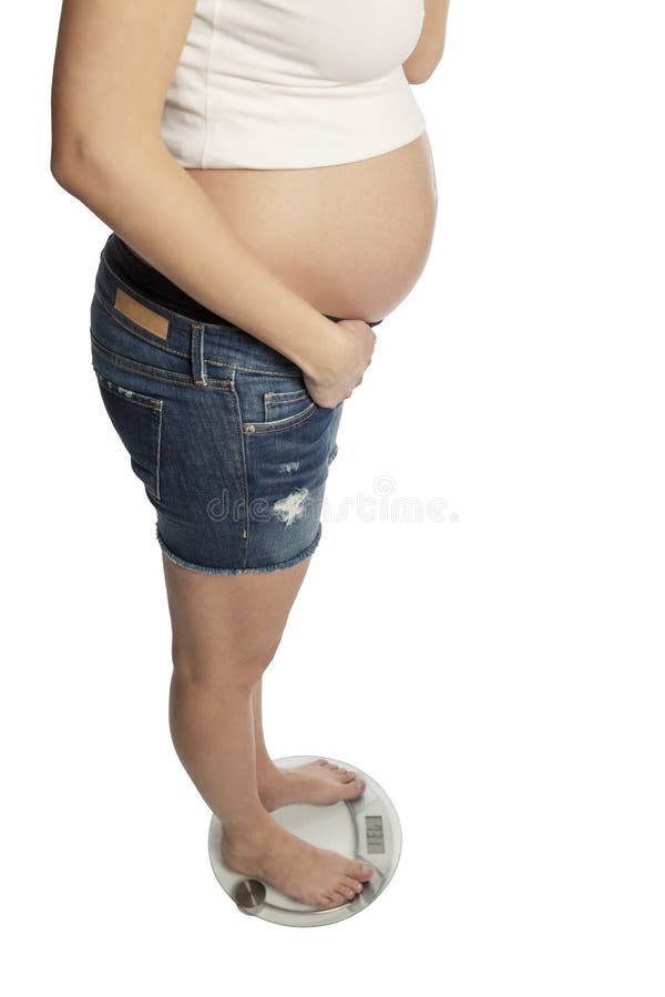 Una giovane donna incinta sta sulle scale Isolato su priorit? bassa bianca immagine stock libera da diritti Una giovane donna incinta sta sulle scale Isolato su priorit? bassa bianca immagine stock libera da diritti