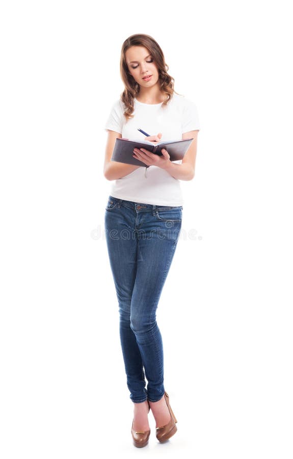 Una giovane donna in jeans che scrive su un taccuino fotografie stock libere da diritti Una giovane donna in jeans che scrive su un taccuino fotografie stock libere da diritti