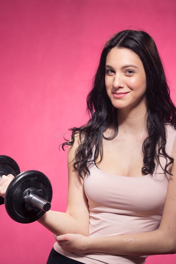 Una giovane donna, testa di legno pesa la tenuta, fondo rosa immagini stock Una giovane donna, testa di legno pesa la tenuta, fondo rosa immagini stock