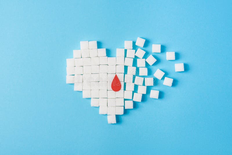 Una goccia di sangue su cuore rotto fatto dei cubi bianchi puri di zucchero isolati su fondo blu, giornata mondiale del diabete fotografia stock libera da diritti Una goccia di sangue su cuore rotto fatto dei cubi bianchi puri di zucchero isolati su fondo blu, giornata mondiale del diabete fotografia stock libera da diritti