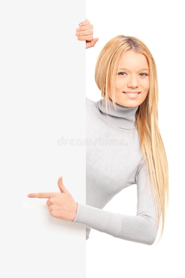 Una hembra rubia hermosa que señala en un panel foto de archivo libre de regalías Una hembra rubia hermosa que señala en un panel foto de archivo libre de regalías