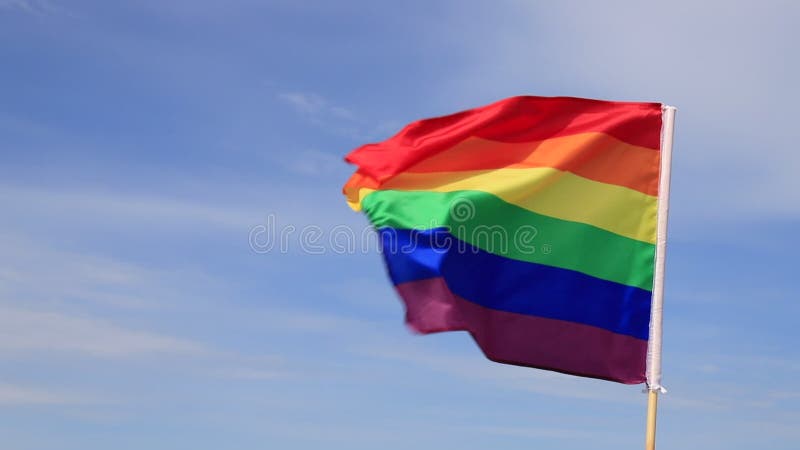 Una hermosa bandera arcoíris de la organización lgbt vuela en el cielo. banderas del orgullo lgbt usadas por lesbianas gays bisexu