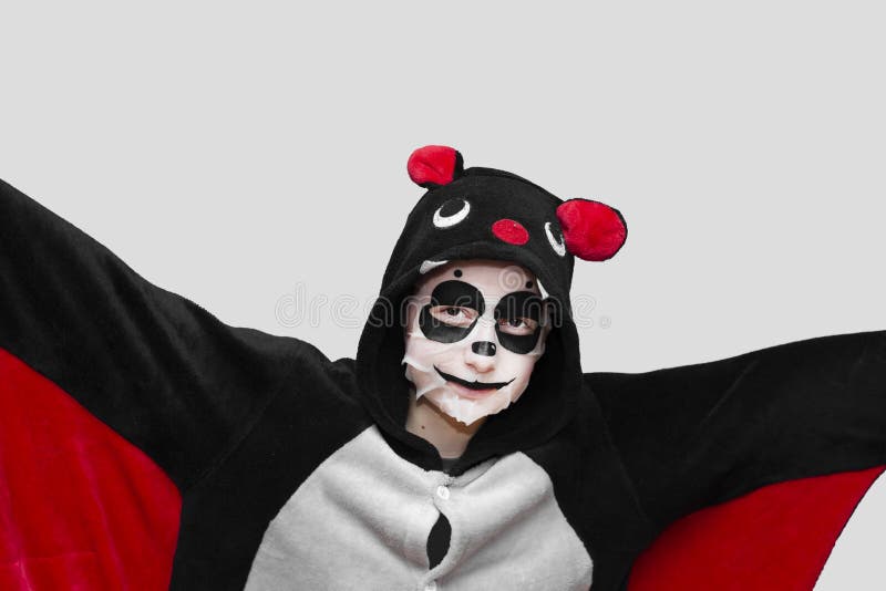 Una Joven Adolescente Con Un Murciélago Y Una Máscara En Su Cara En Forma De Animal Panda Con Fondo Gris. Imagen de archivo - Imagen de belleza, cosméticos: 255439031