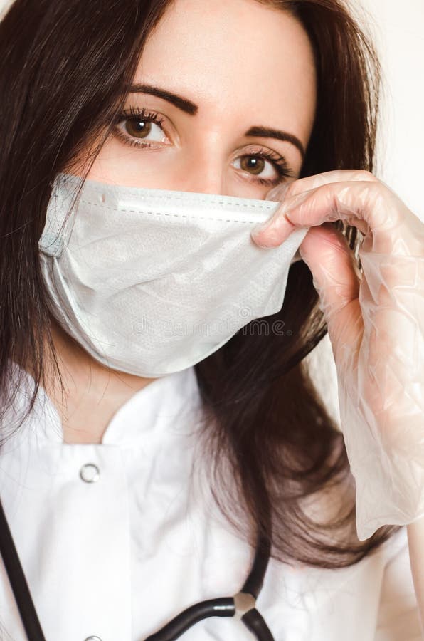 Una joven doctora usa protección contra virus cara máscara médica y guantes fotografía de archivo libre de regalías