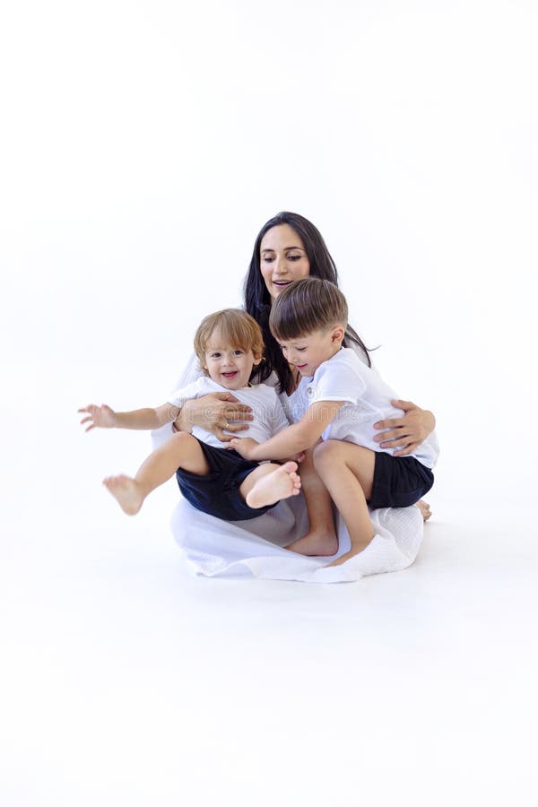 Una joven embarazada con un vestido blanco con sus lindos hijos fotografía de archivo libre de regalías