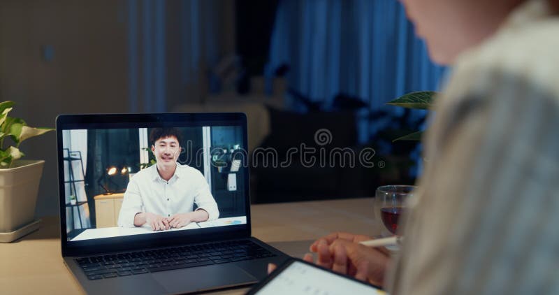 Una joven empresaria asiática lleva un asiento formal frente a su escritorio con tabletas sujetadas con lápiz foco en la pantalla metrajes
