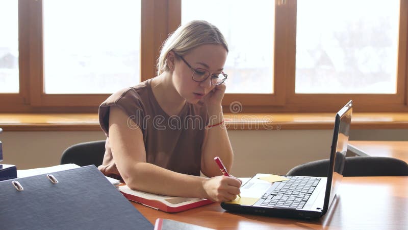 Una joven empresaria está trabajando en su oficina. rubia en su escritorio de la oficina.