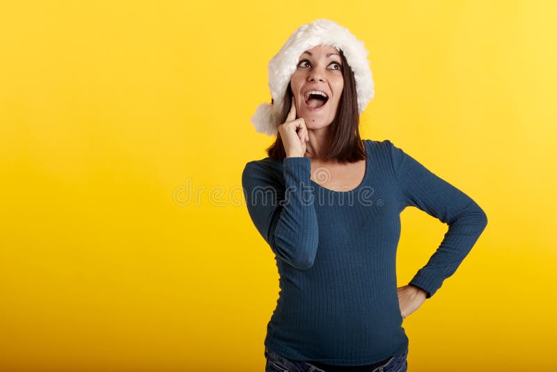 Una joven que tiene una idea en un sombrero de santa foto de archivo libre de regalías