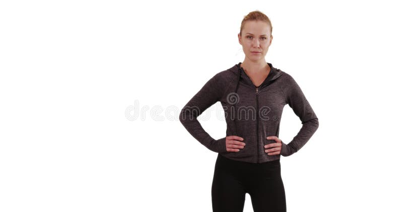 Una joven rubia severa de fondo blanco posando orgullosamente con las manos en las caderas almacen de metraje de vídeo