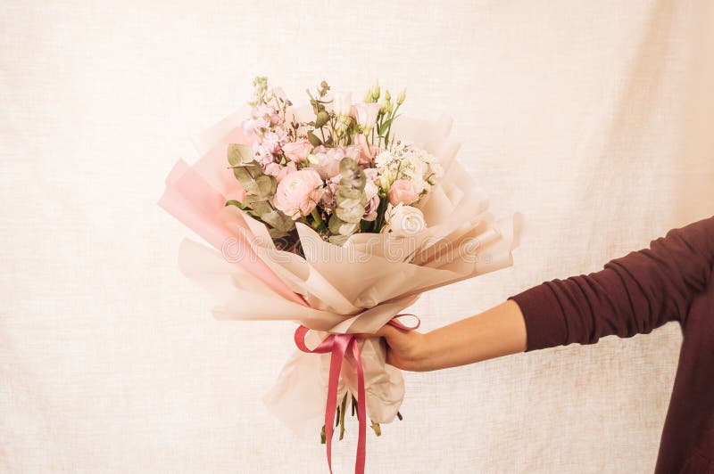 Una joven sostiene un gran y hermoso ramo de rosas frescas eustoma matiola freesia eucalyptus hidrangea en rosa delicado fotografía de archivo libre de regalías