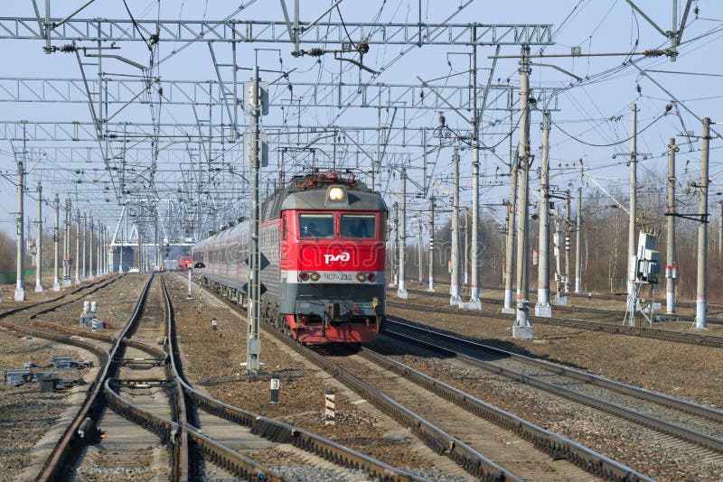 Una locomotiva elettrica a due sezioni di ChS7 con il treno passeggeri sul pomeriggio delle strade ferrate in primavera fotografie stock Una locomotiva elettrica a due sezioni di ChS7 con il treno passeggeri sul pomeriggio delle strade ferrate in primavera fotografie stock
