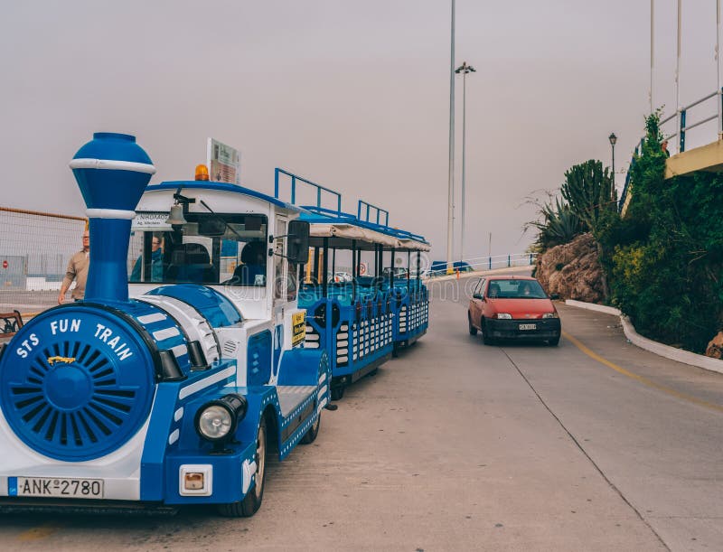 Una locomotiva a vapore blu attraversa le strade della città di Creta fotografia stock libera da diritti Una locomotiva a vapore blu attraversa le strade della città di Creta fotografia stock libera da diritti