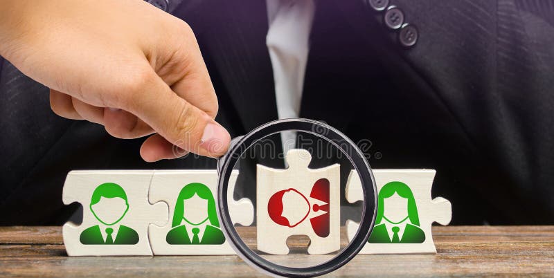 A magnifying glass looks at a businessman sitting in despair over the not assembled puzzles symbolizing a team of employees. Toxic or incompetent worker who fails to comply tasks and disrupts. A magnifying glass looks at a businessman sitting in despair over the not assembled puzzles symbolizing a team of employees. Toxic or incompetent worker who fails to comply tasks and disrupts